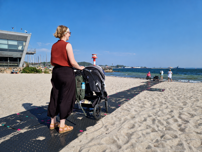 Con el carrito de bebé por el camino de playa móvil